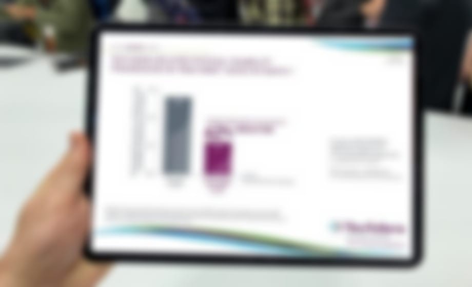 Hands holding a tablet showing a bar chart of study data