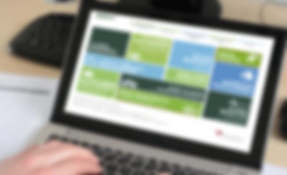 Laptop showing an education website with a grid of coloured content tiles